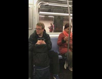 Guy practices playing his flute in a subway station