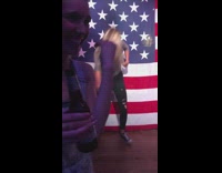 Drunk girl dances crazy at bar in front of big american flag 