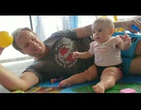 Pink shirt baby girl catches yellow ball 