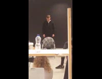 Guy tries to jump over chair with plaid jacket, trips over back rest and falls down