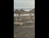 Woman in bikini lie down at the beach shore at sunset