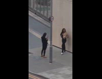 Guards with rifles stop woman beside wall