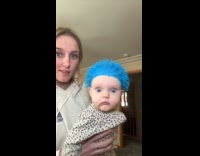 Baby wearing popped rubber ball as hat