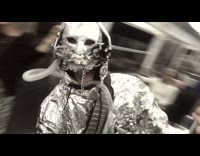 Aluminum foil man with metal mask records himself with bus passengers and dances on pole