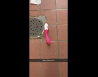 Pink white vibrator on public restroom floor 