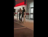 Three people tiktok dance in front of a restaurant
