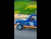 Guy drives toy car on street 