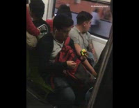 man solves rubix cube with one hand on subway