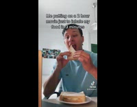 Guy blue shirt eating sandwich opens laptop