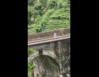 Man shirtless with pants poses on the railway bridge