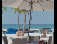 Girl string bikini kneel beach umbrella chairs