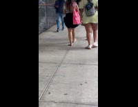 Woman walks barefoot on the scaffolding sidewalk