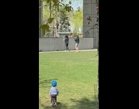 Blue helmet little boy watches girls dance 