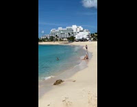 Small plane fly over woman swim beach 