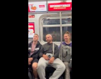 Man hangs on handrail for train performance