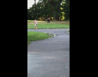 Guy swings a whip at park 