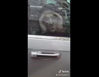 Girl parking car next to her scary face staring back