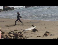 Guy Filmed Doing Karate Poses Next to Board on Beach