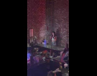 Girl holds drink and dances in bar 