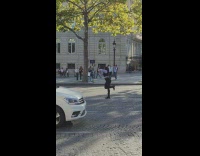 Woman in black and white outfit tiktok dance in the middle of the street