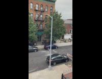 Guy lowers trash bag from window dumpster 