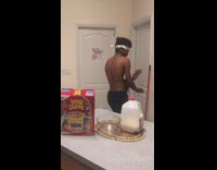Guy spin kicks milk bottle cap open, twists it off with hand, and pours cereal in bowl