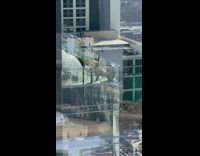 Two women dance on a building balcony