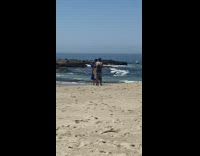 Girl blue graduation gown beach sand 