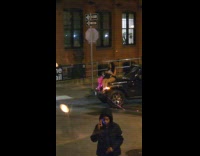 Woman sits on car hood blocks road
