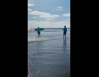 Man Hotdog costume surfboard walk seaside beach