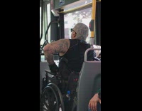 Man in wheelchair and fully body tattoos has fuck the police tattooed on back of his head on bus