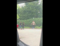 Guy brown shirt move arms beside bushes