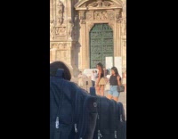 Collab IITW - Person in skirt black sleeveless poses middle of Milan with tripod