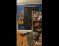 Guy picks up shirt throws piano at clothing basket 