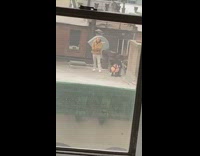 Woman stands on rooftop in thong underwear with guy in brown jacket