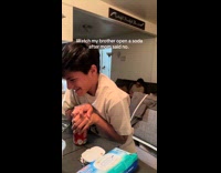 Boy trying to open soda quietly 