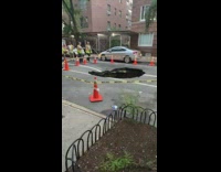 Large sink hole surrounded by caution tape