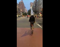 Guy wears hat of tall silver building 