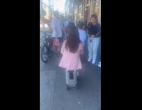 Three people ride suitcase with wheels street