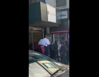 Guy carries white feather umbrella black pants