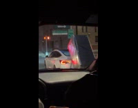 White car carry refrigerator on back drive street