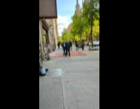 Collab WINY - Man vacuum clean large rug on sidewalk