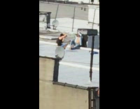 Guy unbuttoned shirt sits rooftop satellite dish 