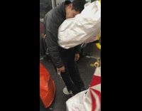 man sleeping on white bag standing up subway