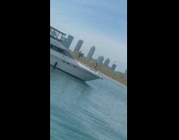 Man shirtless feet in air balance yacht