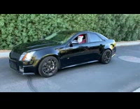 man dressed as santa in black car revs 