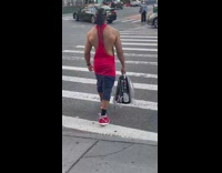 Bodybuilder guy holding a backpack for pets with a ferret inside 
