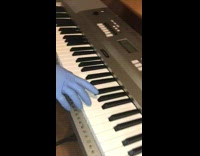 Person pretends to play keyboard blue glove 