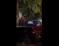 People watch baseball match on street with projector