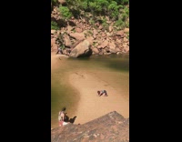 Girl handstand pose brown ground water rocky